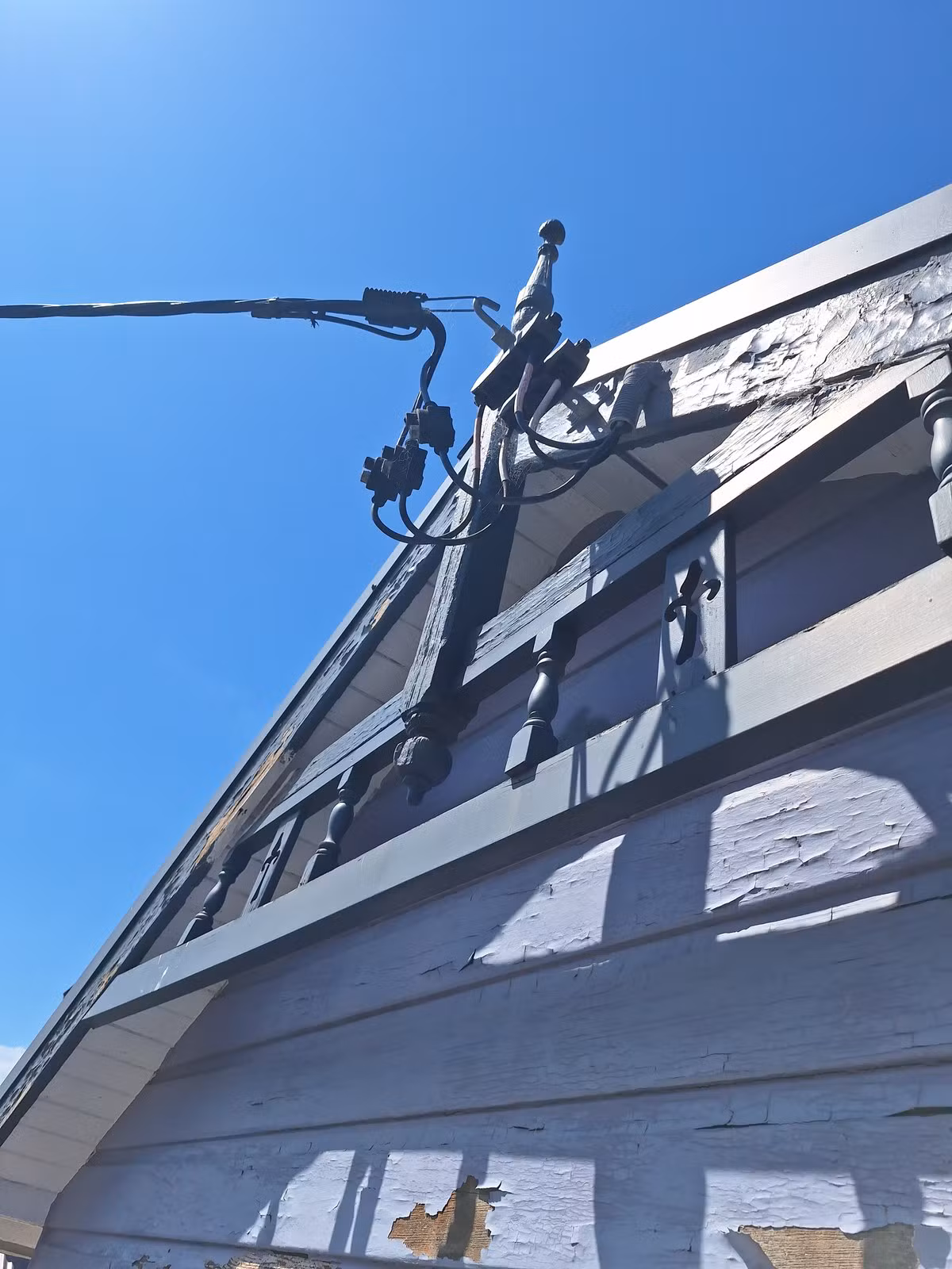 Failing paint on the old timber gable before preparation