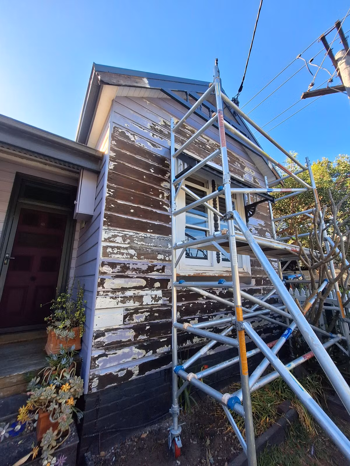 Maryville weatherboard facade during preparation with areas of bare timber exposed