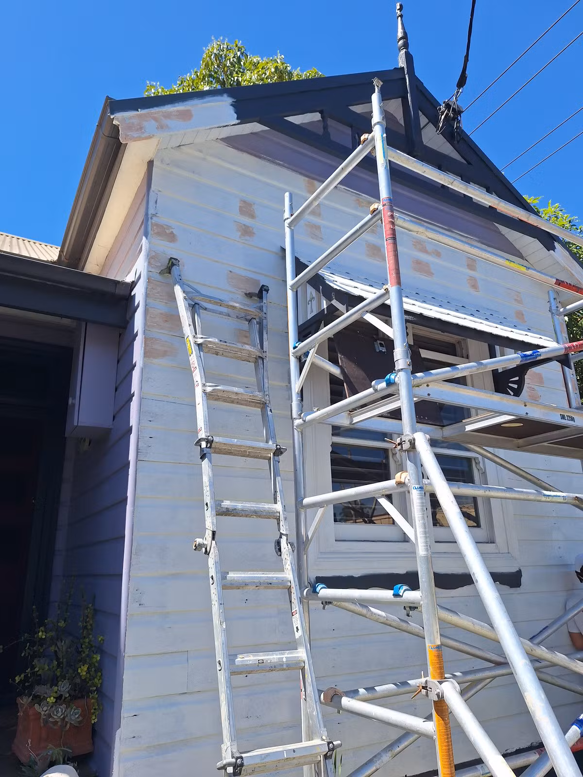 Undercoated Maryville facade with the upper gable already painted