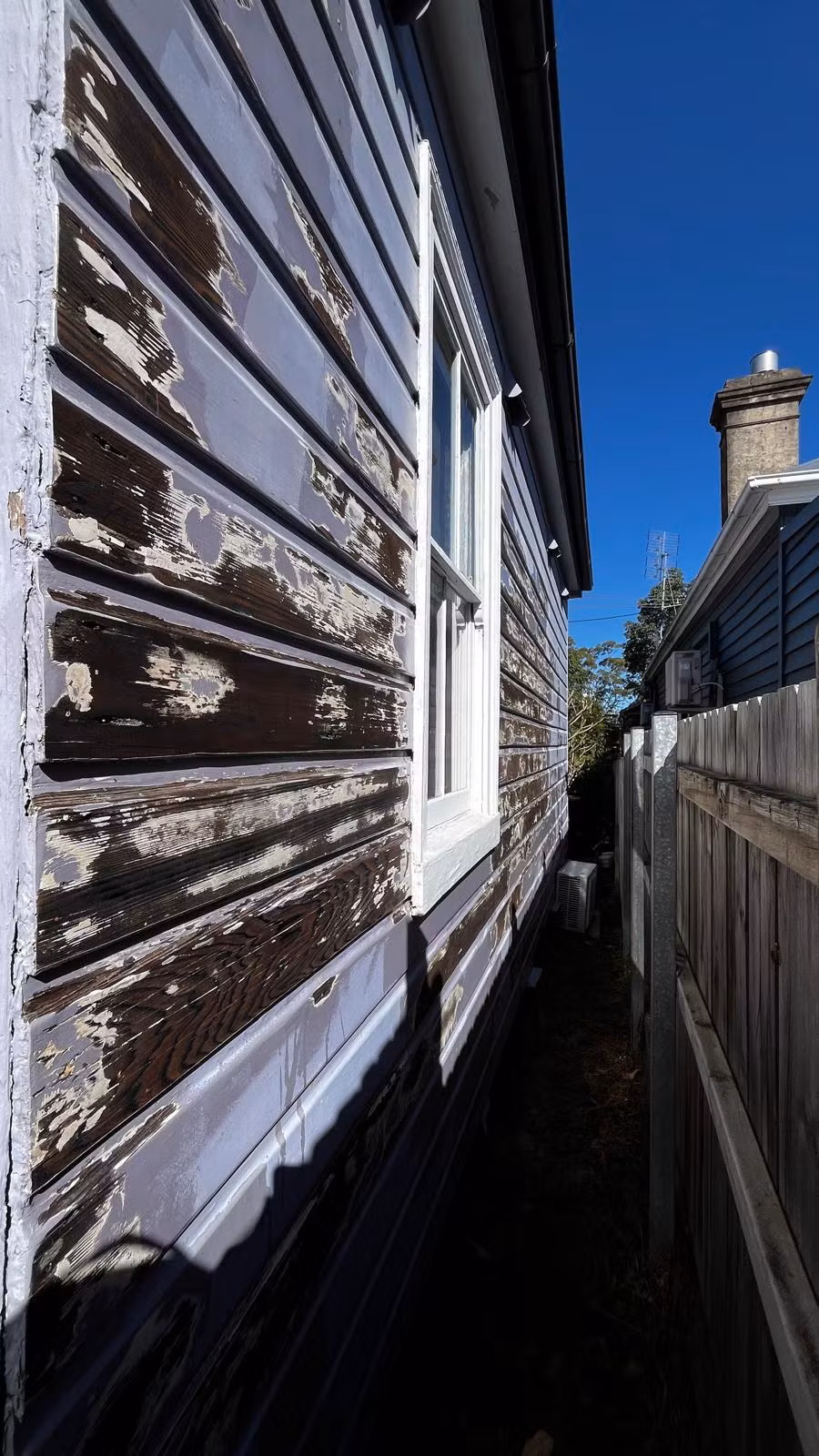 Weathered side-wall boards during preparation before repainting