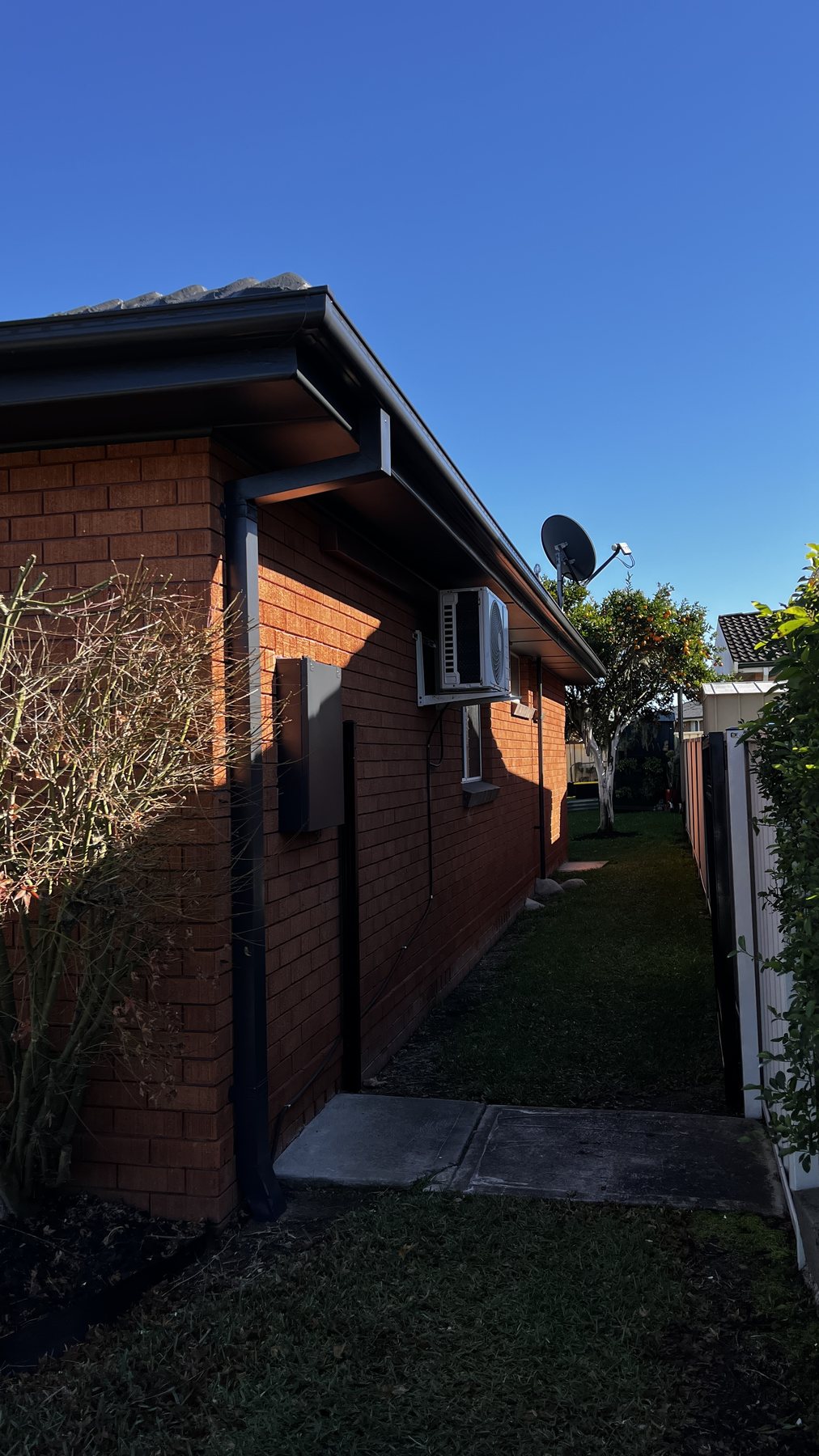 Gloss Domino downpipe, fascia and gutter on the finished side elevation